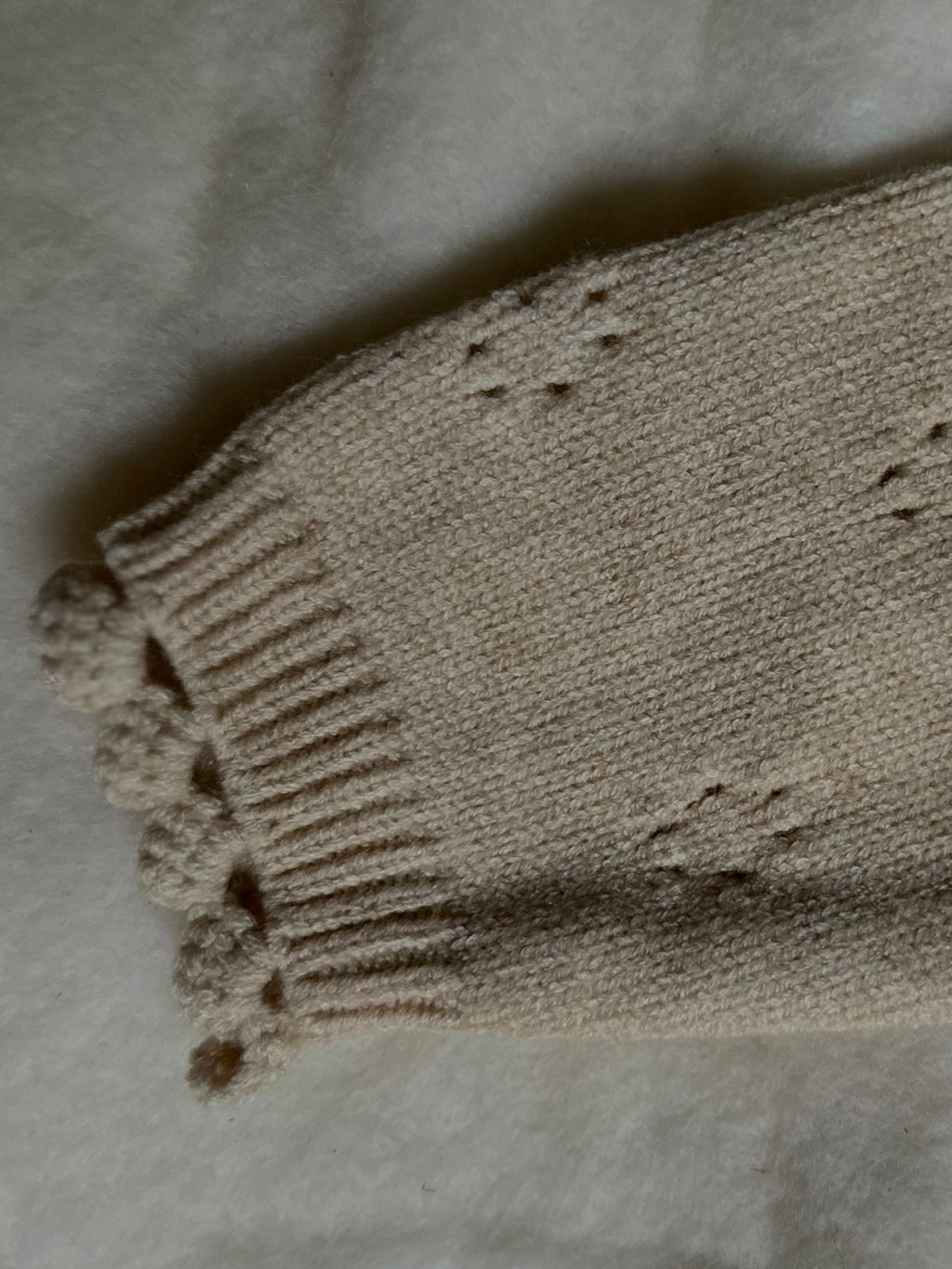 Details on sleeves of Apricot tan soft and thick polyester blend cardigan with buttons, pointelle design. 