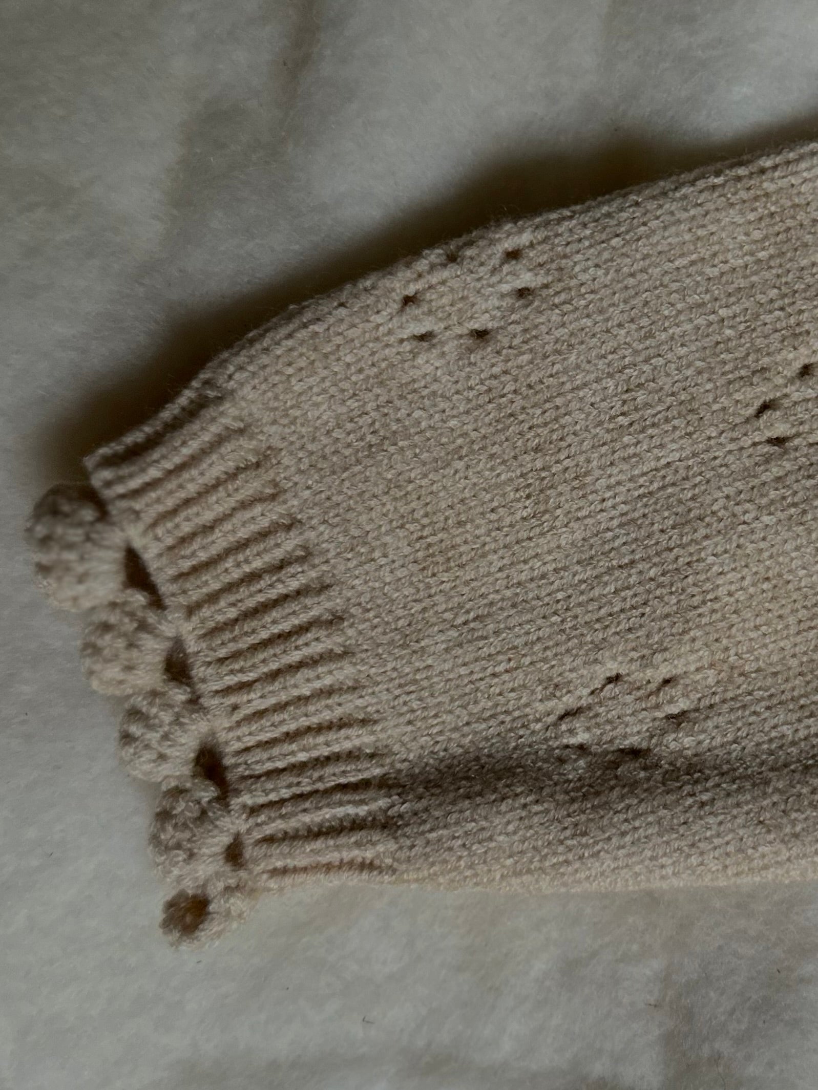 Details on sleeves of Apricot tan soft and thick cardigan with buttons, pointelle design. 