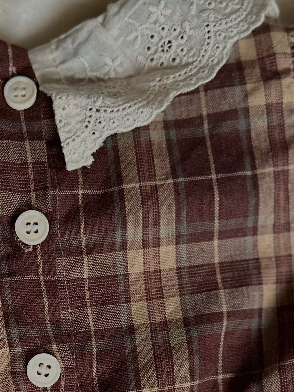 Details of back lace collar and buttons In back of 100% cotton Brownish plaid bubble romper with lace front and collar. 