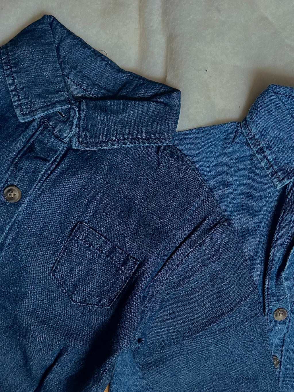 Medium to dark and light o dark wash denim shirts, long sleeve, collar, buttons, 100% cotton next to each other. 