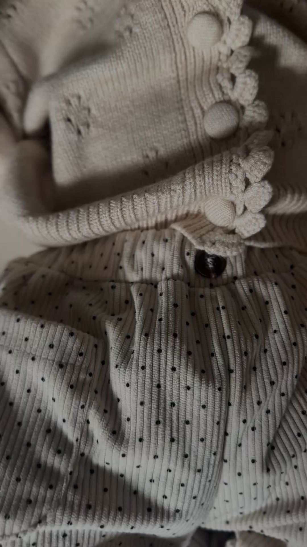 Video of baby wearing Light cream colored soft polka dot corduroy pants with button. 