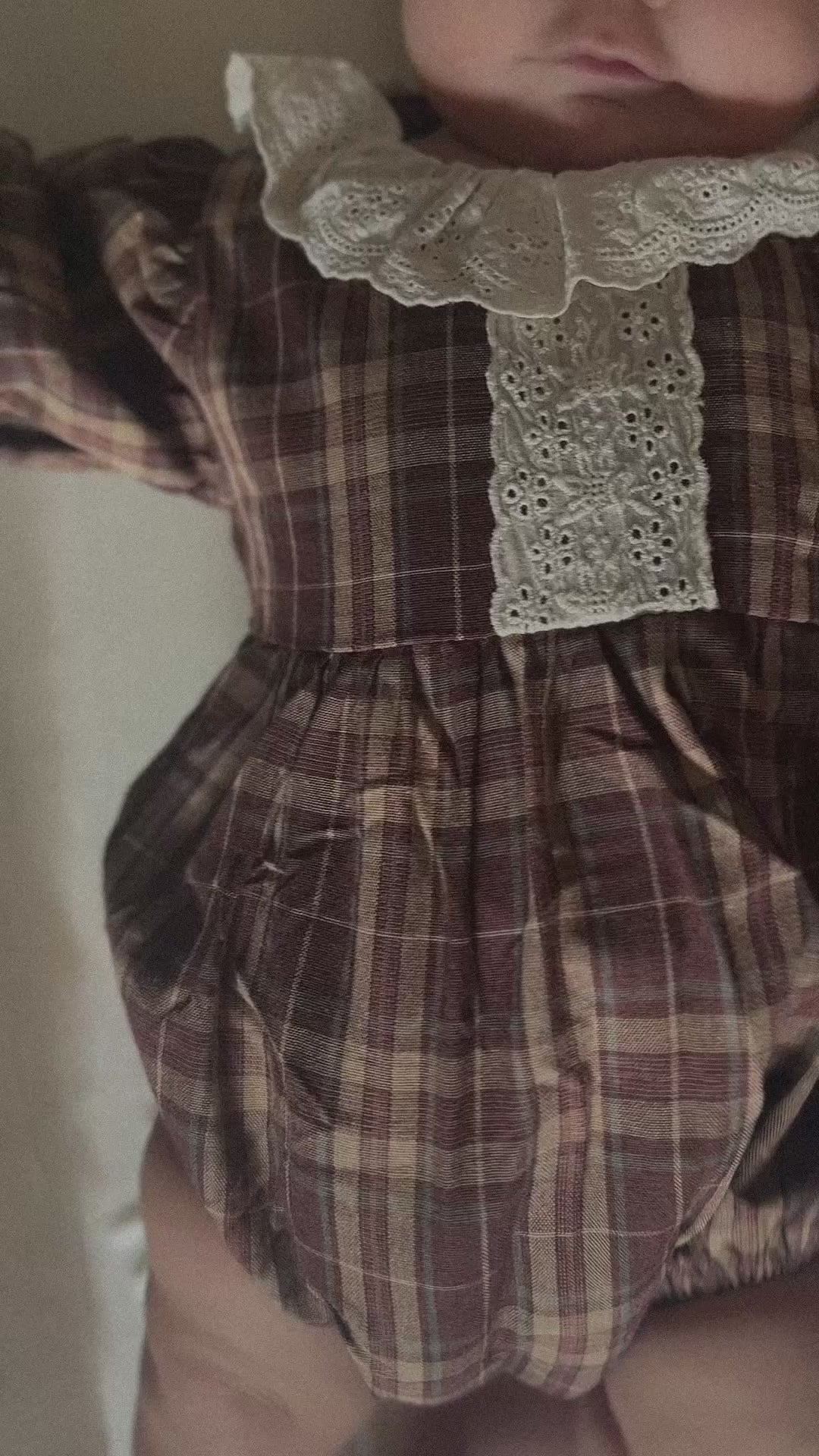 Video of baby wearing 100% cotton Brownish plaid bubble romper with lace front and collar. 