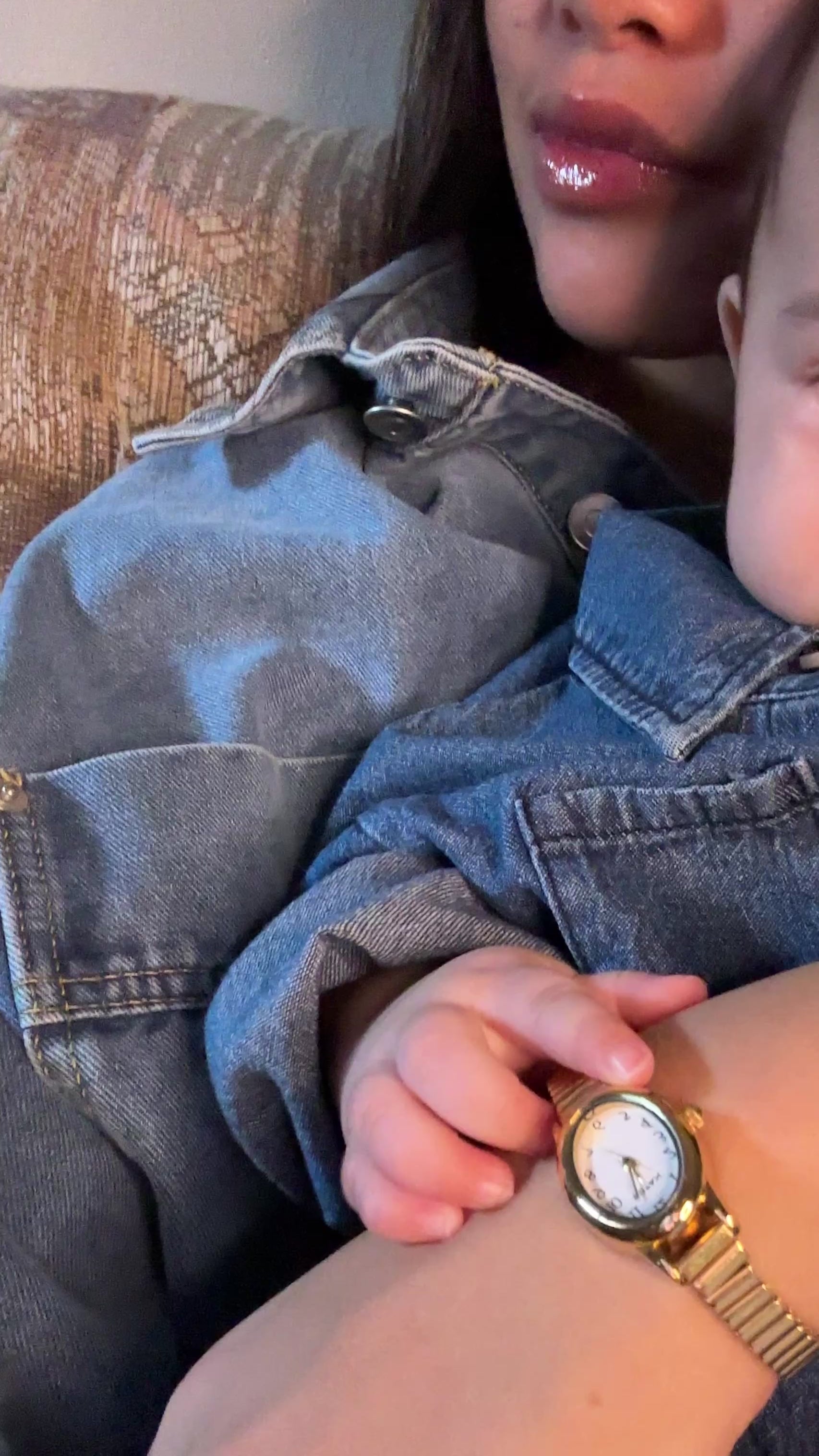 Video of to medium wash 100% cotton denim shirt, long sleeve, collar, buttons on baby with mother holding baby wearing similiar matching denim shirt. 